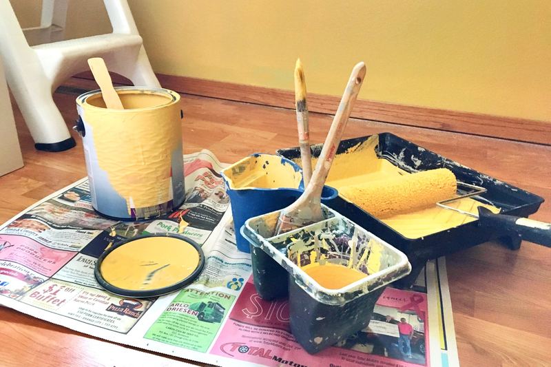 Indoor painting supplies including rollers and trays